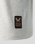 Close up of a brown Castore patch with Oracle Red Bull Racing branding on light gray fabric.