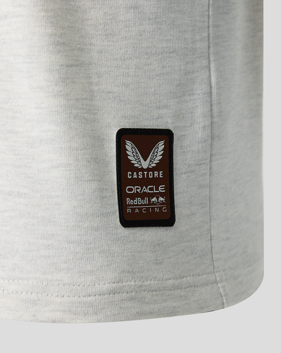 Close up of a brown Castore patch with Oracle Red Bull Racing branding on light gray fabric.